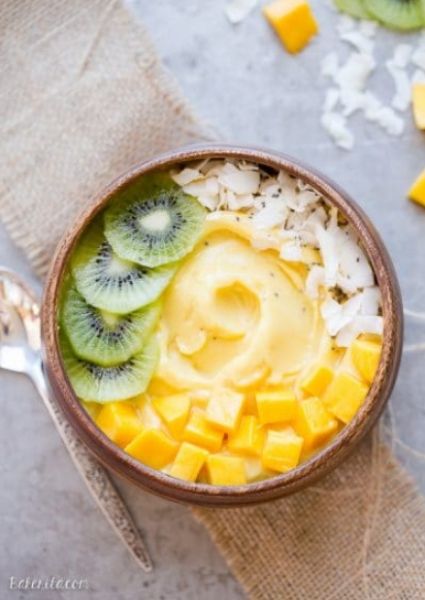 Mango Pineapple Smoothie bowl with kiwi slices, coconut flakes and mango 