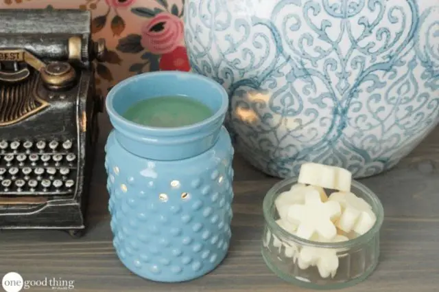 Blue candle aromatherapy furnace with bowl of wax melts beside it