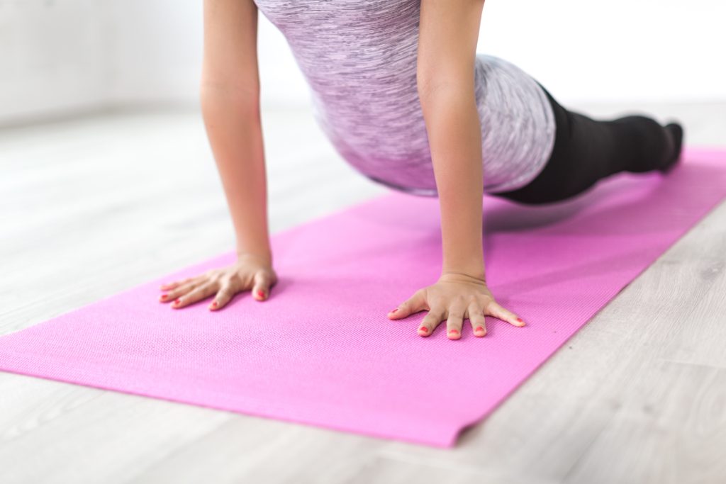 Girl doing workout on a pink yoga mat