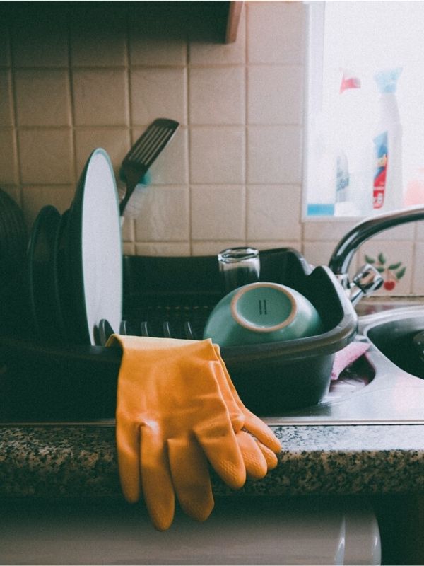 Yellow gloves latex on a dish rack.